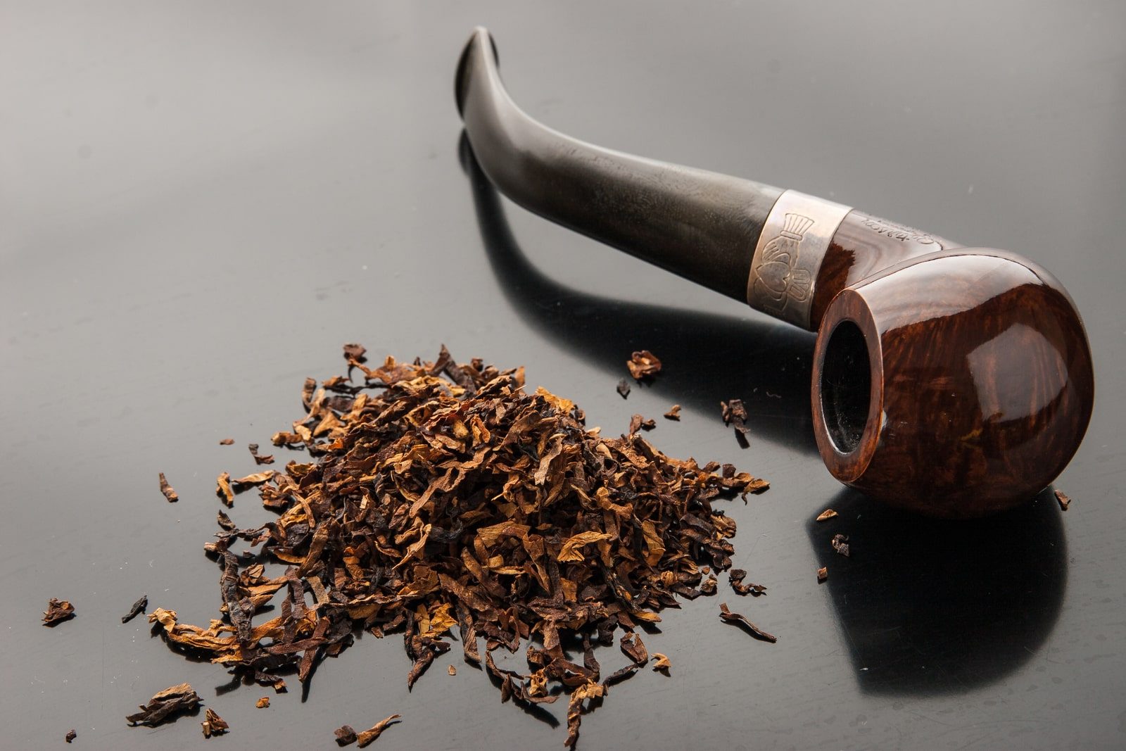22588916_pipe-with-tobacco-on-the-dark-table-min Pipe with tobacco on the dark table